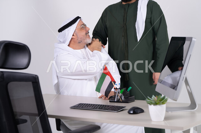 رجال أعمال إماراتيين في مكتب مع علم الإمارات