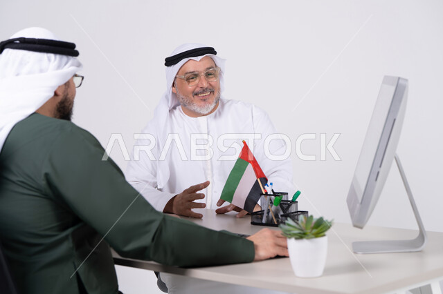 رجال أعمال إماراتيون في اجتماع مكتبي مع علم الإمارات