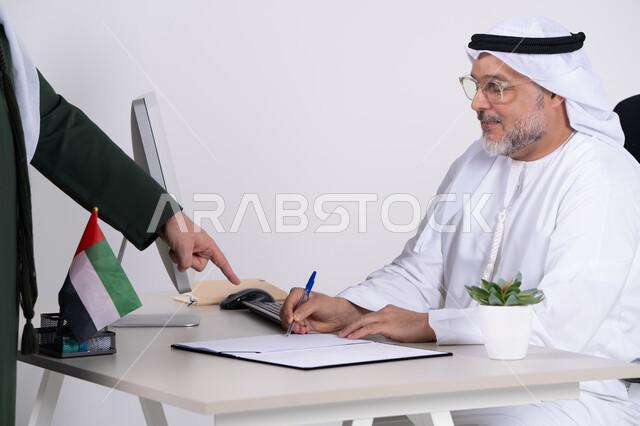 رجل أعمال إماراتي يوقع عقداً في مكتب عمل