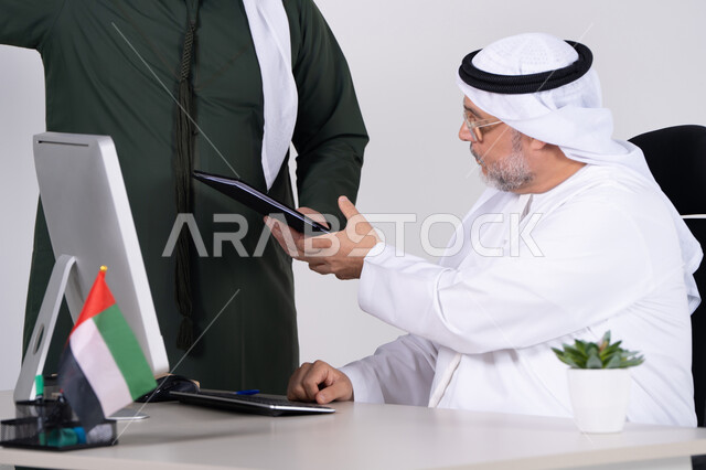 رجل أعمال إماراتي يستلم مستند في المكتب
