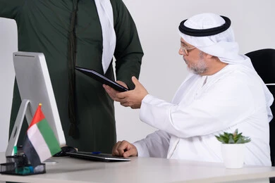 رجل أعمال إماراتي يستلم مستند في المكتب