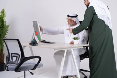 Emirati Businessmen Discussing Work on Computer Screen