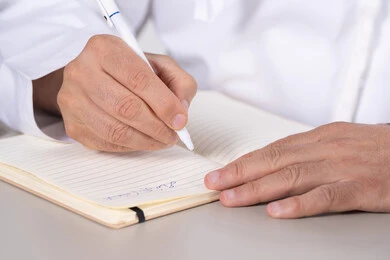 Emirati Man Writing in Notebook Close-up Shot