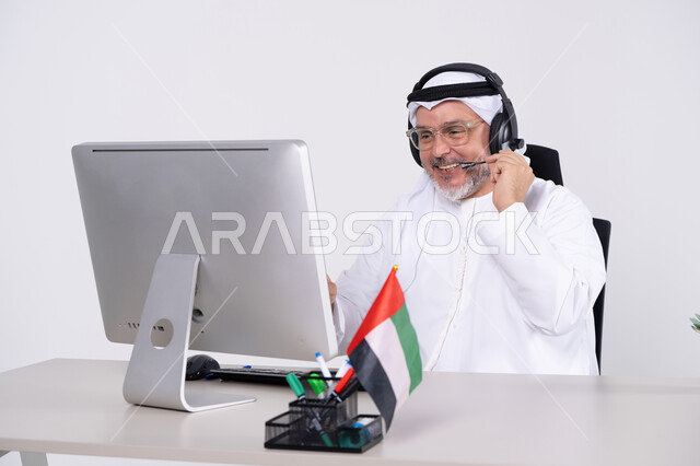 رجل أعمال إماراتي مع سماعة رأس في المكتب
