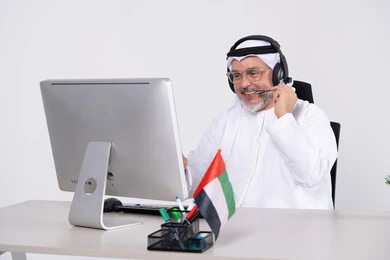 رجل أعمال إماراتي مع سماعة رأس في المكتب