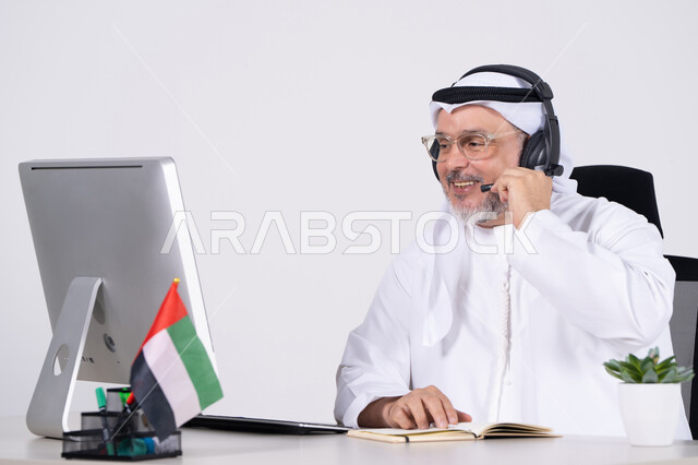 رجل أعمال إماراتي مع سماعة في مكتب عمل