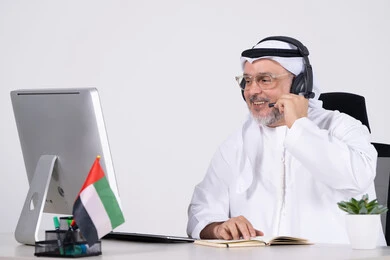 رجل أعمال إماراتي مع سماعة في مكتب عمل