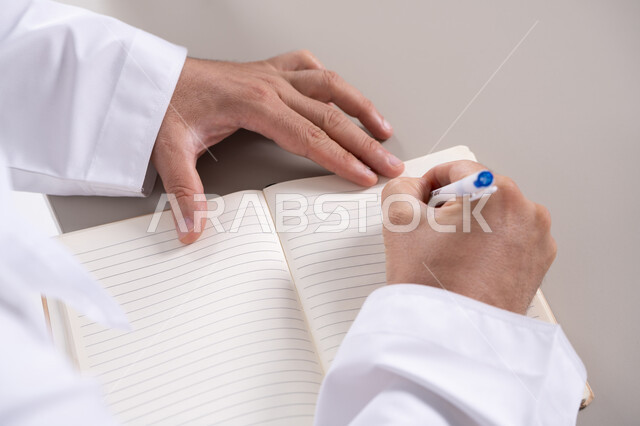 رجل إماراتي يكتب في دفتر ملاحظات لقطة قريبة