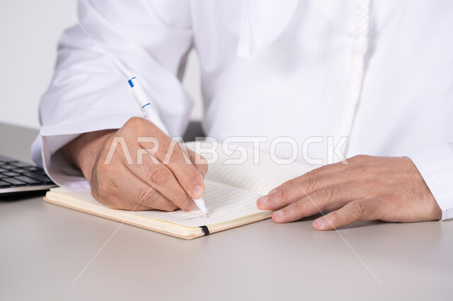 رجل أعمال إماراتي يكتب في دفتر ملاحظات