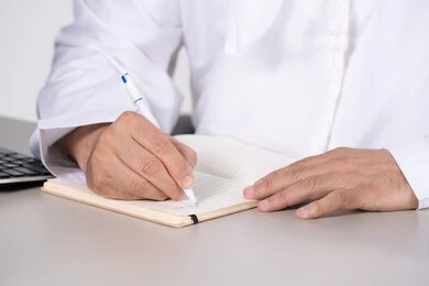 رجل أعمال إماراتي يكتب في دفتر ملاحظات