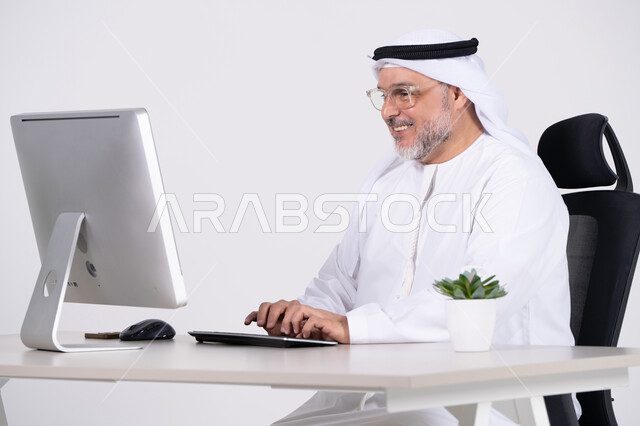 رجل أعمال إماراتي يعمل على الكمبيوتر في المكتب