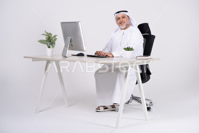 رجل أعمال إماراتي على مكتب عمل حديث مع كمبيوتر