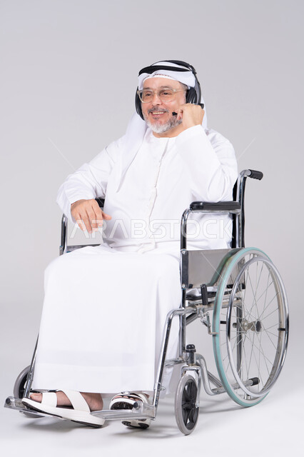 رجل إماراتي بكرسي متحرك يرتدي سماعة رأس