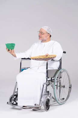 Emirati Man in Wheelchair Holding Traditional Handicrafts