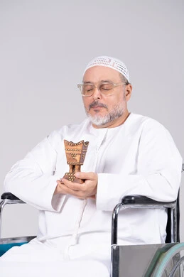 رجل إماراتي على كرسي متحرك يمسك مبخرة