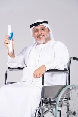 رجل إماراتي مسن على كرسي متحرك يحمل شهادة