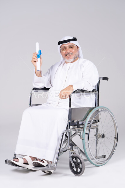 رجل إماراتي على كرسي متحرك يحمل شهادة