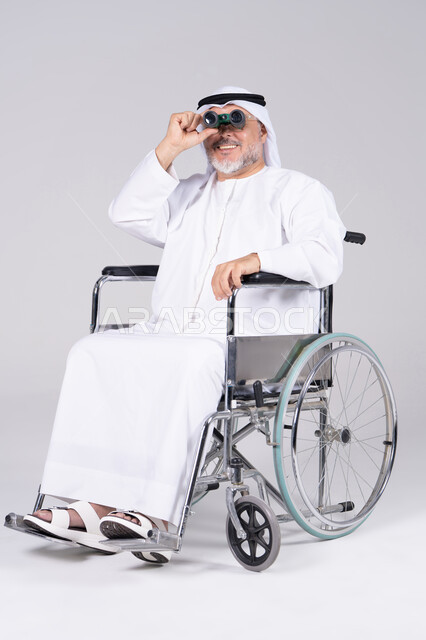 رجل إماراتي على كرسي متحرك يستخدم المنظار
