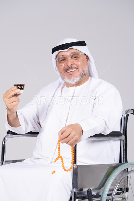 رجل إماراتي مسن على كرسي متحرك مع قهوة عربية