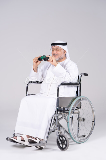 Emirati Man in Wheelchair Holding Binoculars in Studio