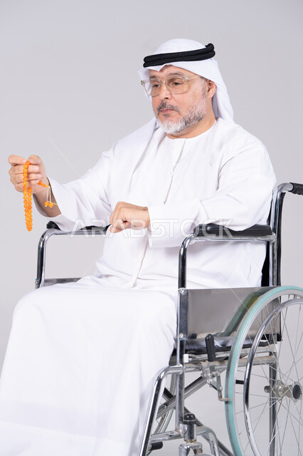 رجل إماراتي مسن على كرسي متحرك مع مسبحة