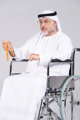 رجل إماراتي مسن على كرسي متحرك مع مسبحة