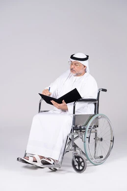 رجل إماراتي مسن على كرسي متحرك يكتب في الاستوديو