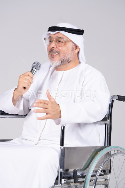 رجل إماراتي مسن على كرسي متحرك يتحدث بالميكروفون