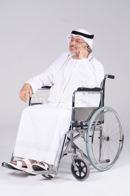 رجل إماراتي على كرسي متحرك يستخدم الهاتف في الاستوديو