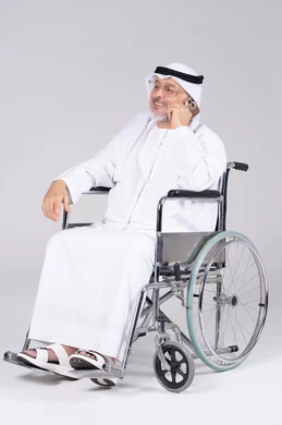 رجل إماراتي على كرسي متحرك يستخدم الهاتف في الاستوديو