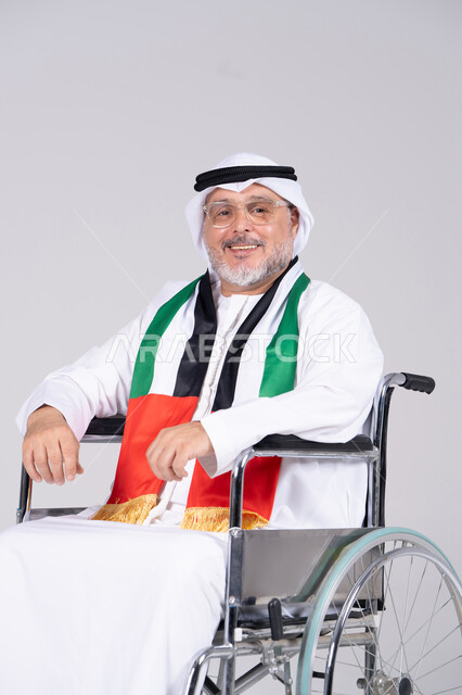 رجل إماراتي مسن على كرسي متحرك مع علم الإمارات