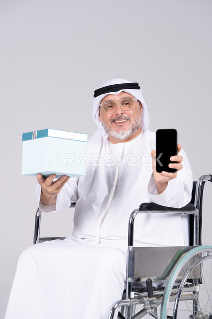 Emirati Man in Wheelchair Holding Gift and Smartphone