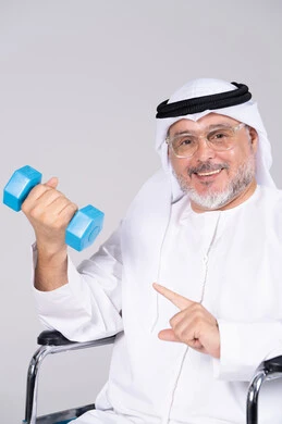رجل إماراتي مسن على كرسي متحرك يمارس الرياضة