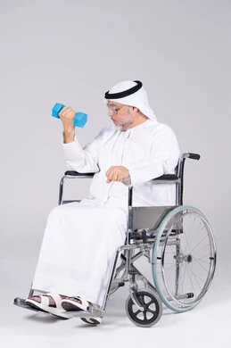 رجل إماراتي على كرسي متحرك يمارس الرياضة بالدمبل