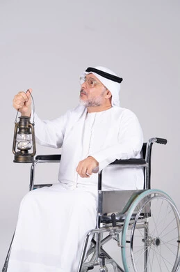 رجل إماراتي على كرسي متحرك يحمل فانوس تقليدي