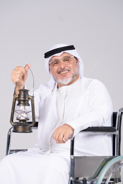 Emirati Senior in Wheelchair Holding Traditional Lantern