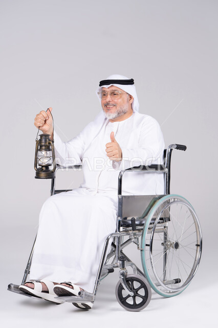 رجل إماراتي مسن على كرسي متحرك يحمل فانوس