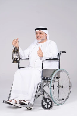 رجل إماراتي مسن على كرسي متحرك يحمل فانوس