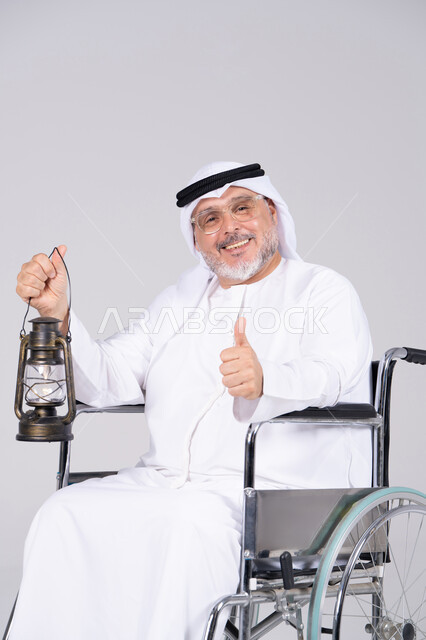 رجل إماراتي مسن على كرسي متحرك مع فانوس