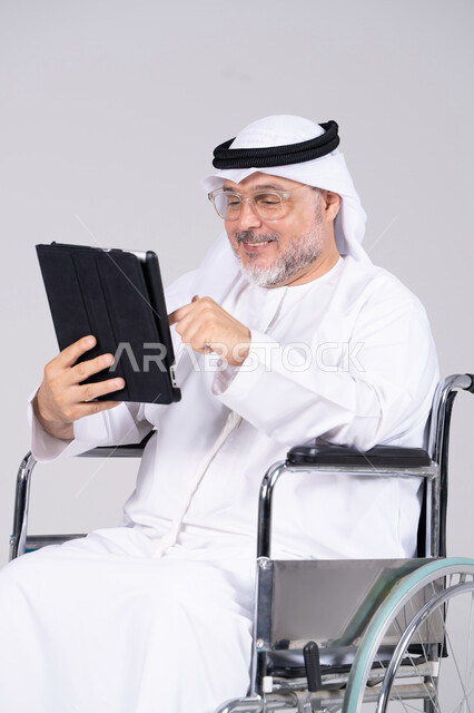 Emirati Man in Wheelchair Using Digital Tablet