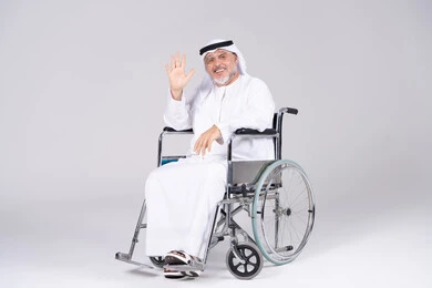 رجل إماراتي مسن على كرسي متحرك بخلفية بيضاء
