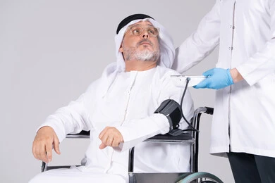 رجل إماراتي مسن على كرسي متحرك يجري فحص طبي