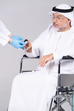 رجل إماراتي مسن على كرسي متحرك يجري فحصاً طبياً