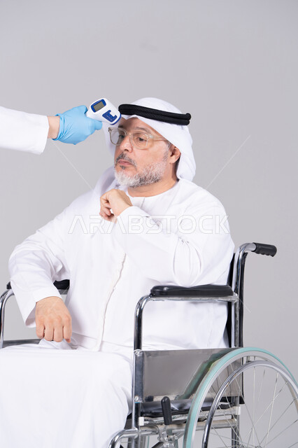 رجل إماراتي مسن على كرسي متحرك فحص درجة الحرارة