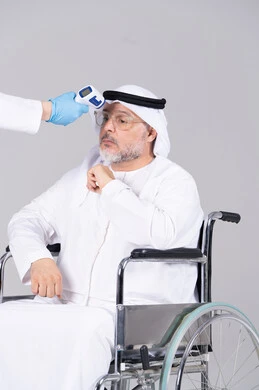 رجل إماراتي مسن على كرسي متحرك فحص درجة الحرارة