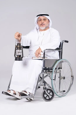 رجل إماراتي مسن على كرسي متحرك يحمل فانوساً
