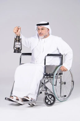 رجل إماراتي على كرسي متحرك يحمل فانوس تقليدي