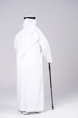 رجل إماراتي بالكندورة التقليدية مع عصا المشي