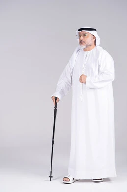 رجل إماراتي مسن مع عصا مشي في الاستوديو