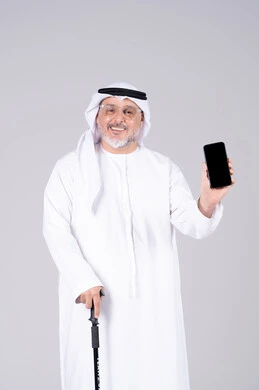 رجل إماراتي مسن يحمل هاتفاً ذكياً بشاشة فارغة